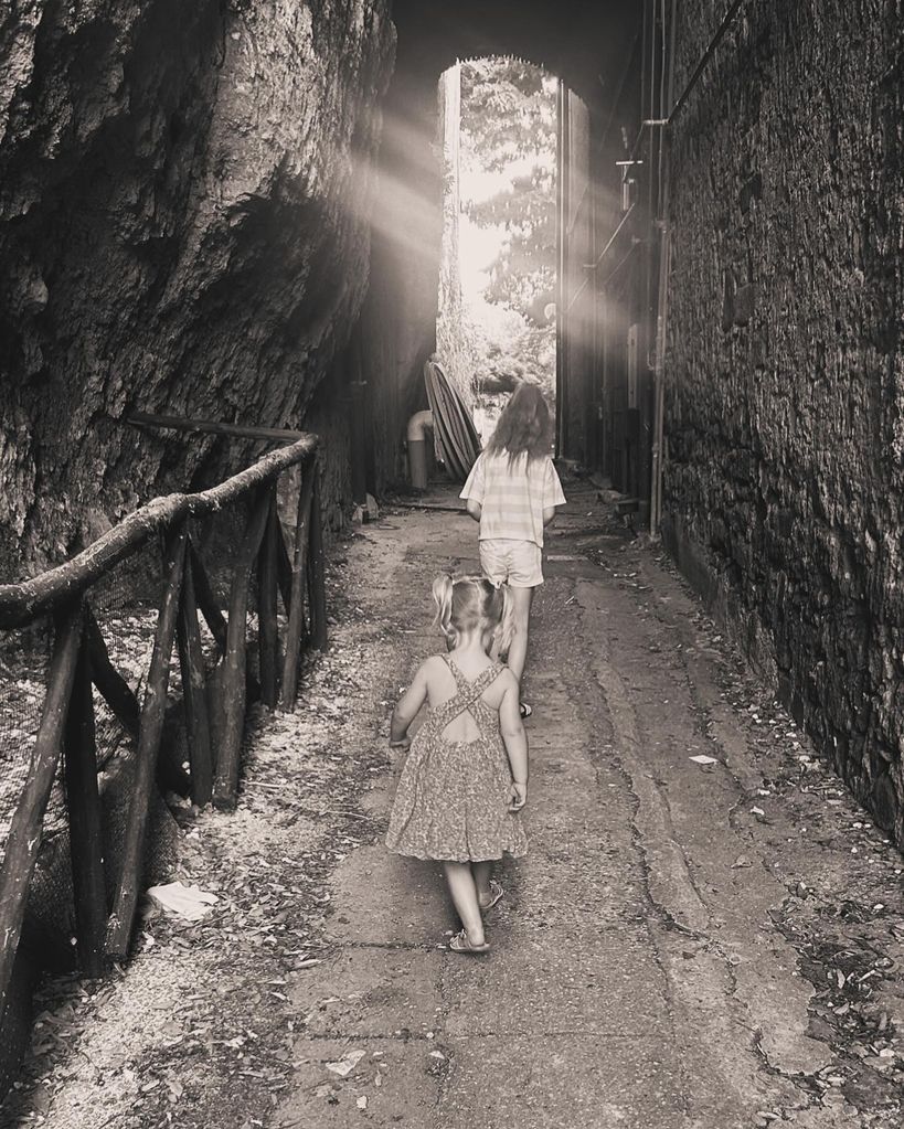 two young girls walking through archway