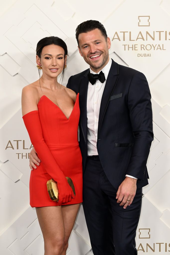 Michelle Keegan in a red dress next to Mark Wright in a tuxedo