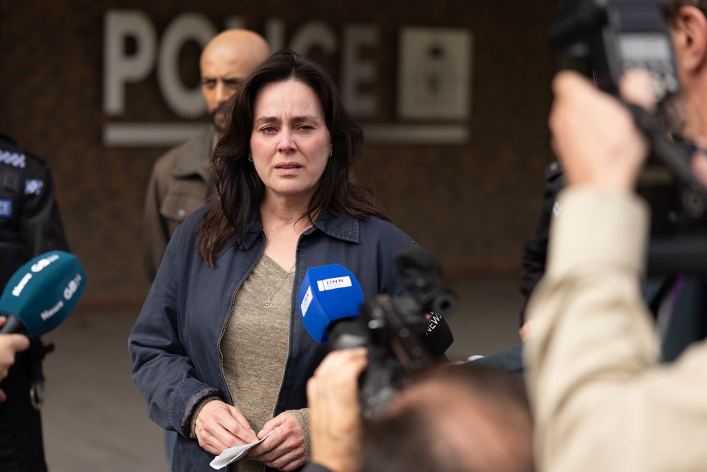 woman standing in front of microphones