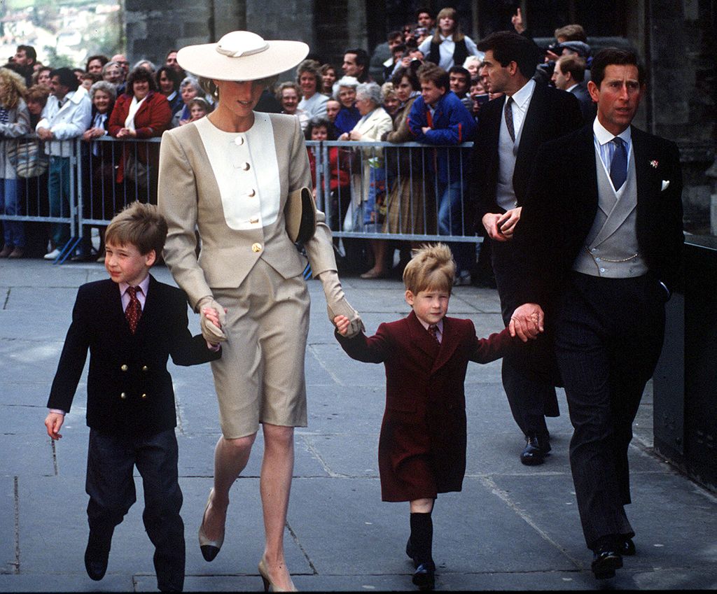 A young Prince William walking with Princess Diana, a young Prince Harry and the then Prince Charles