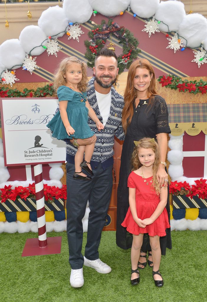 The couple with their daughters at Christmas event