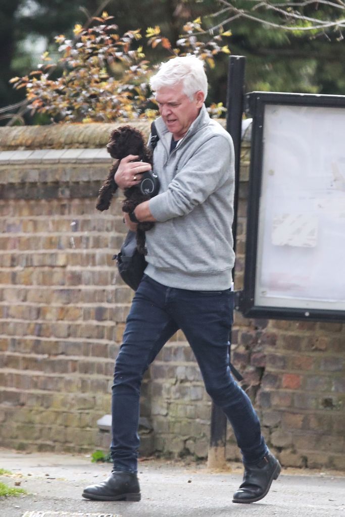 Phillip could be seen holding the cockapoo in his arms