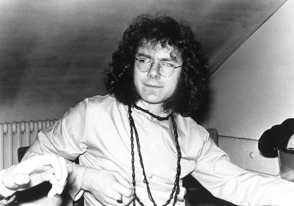 Black and white photo of Robert Fripp with long curly hair