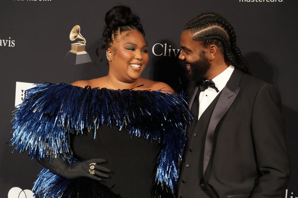 Lizzo wearing a blue tassle, black dress and Myke Wright in a black suit attending the Pre-GRAMMY Gala & GRAMMY Salute 