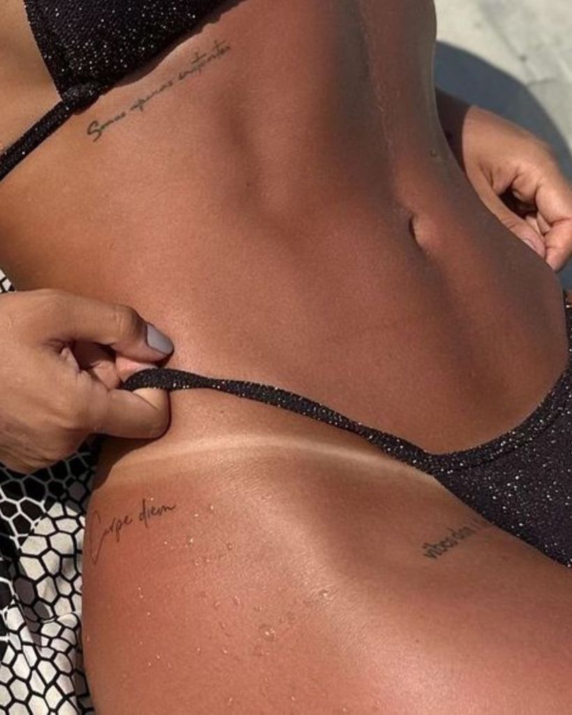 woman in black bikini with spray tan lines