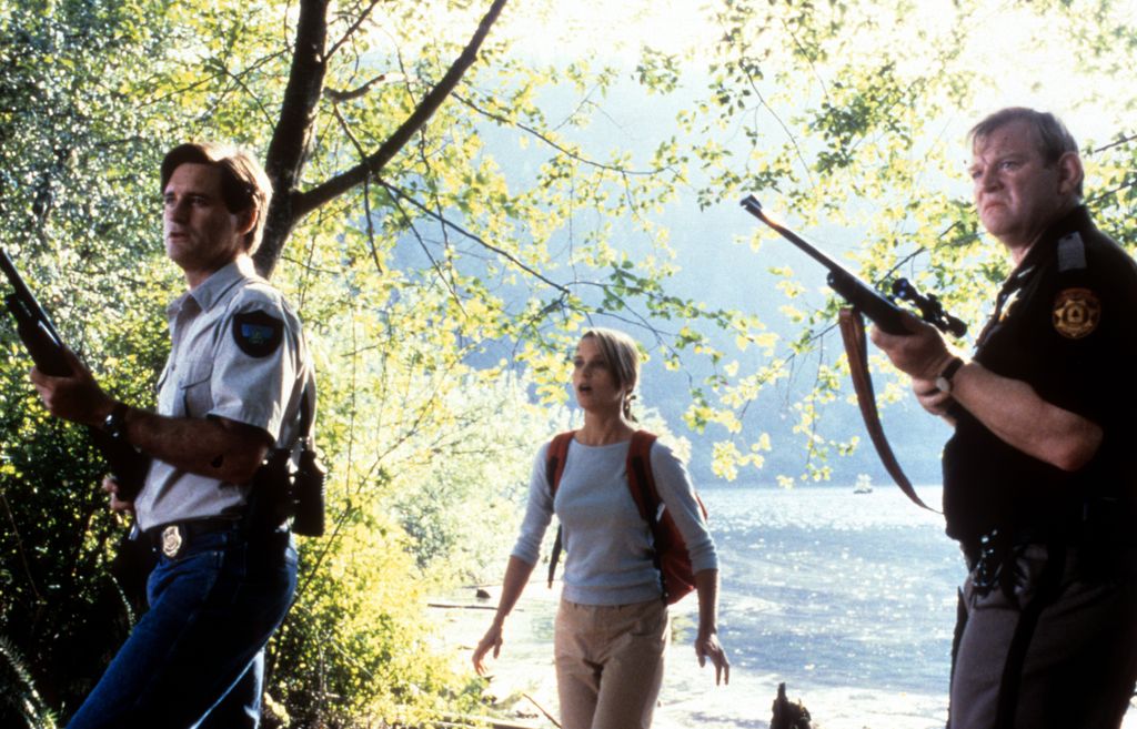 Bill Pullman and Bridget Fonda arm themselves in a scene from the film 'Lake Placid'