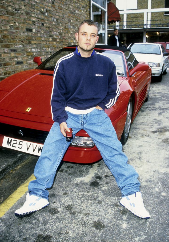 Brian Harvey leaning back on a red Ferrari