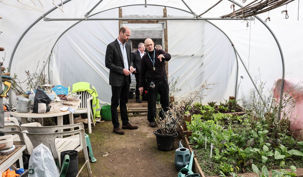 Prince William talks to Dave Richards, Oasis Garden Project Lead while standing in a poly tunnel in the Health and Wellbeing Garden