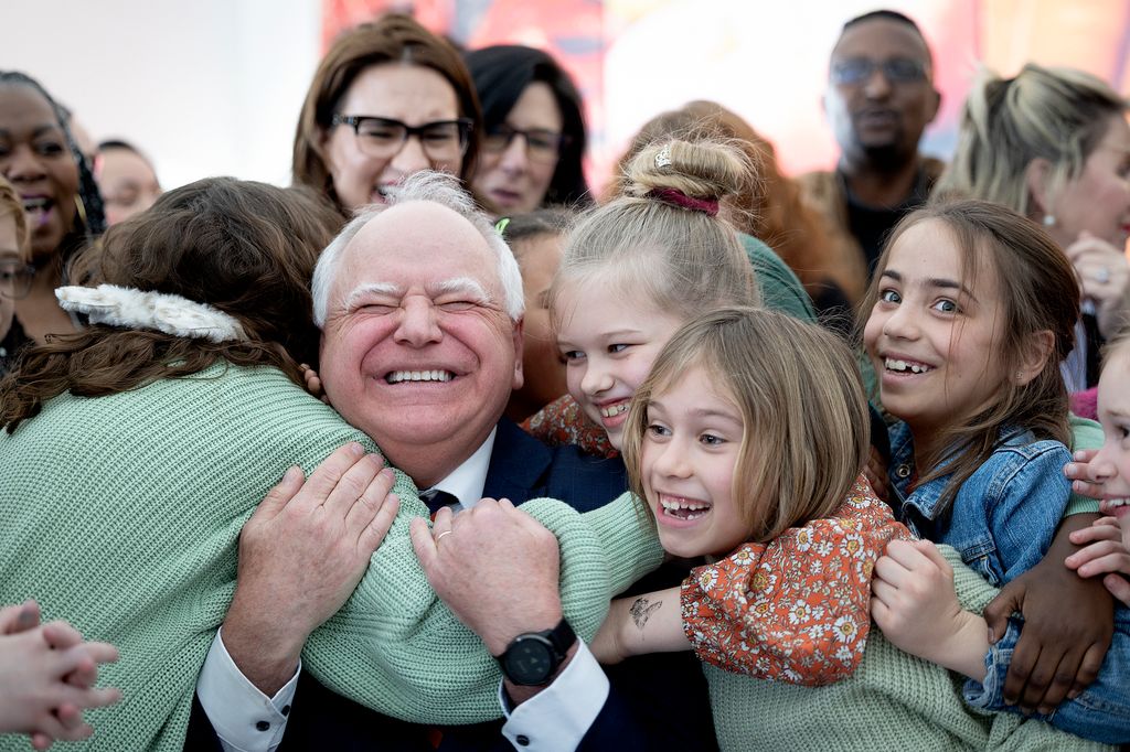 Minnesota Governor Tim Walz receives a warm hug from students at Webster Elementary in Minneapolis, Minnesota, after signing legislation guaranteeing free school meals (breakfast and lunch) to every student in Minnesota's public and charter schools on Friday, March 17, 2023.