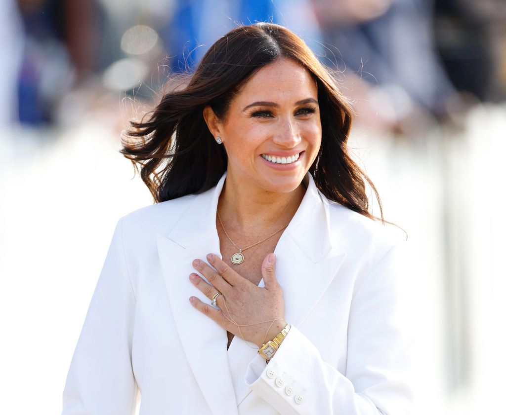 Meghan Markle wearing a white suit and cartier watch