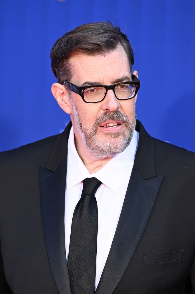 Richard Osman in a black suit