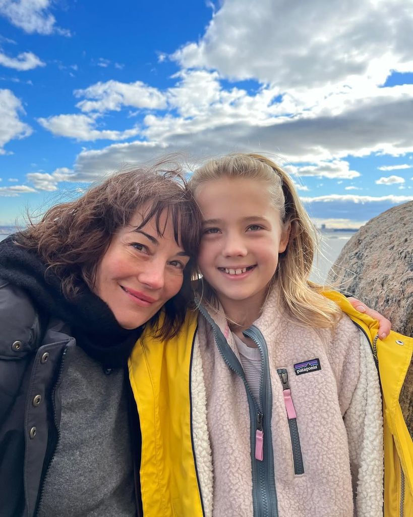 Natasha with her arms around Clover standing on a cliff