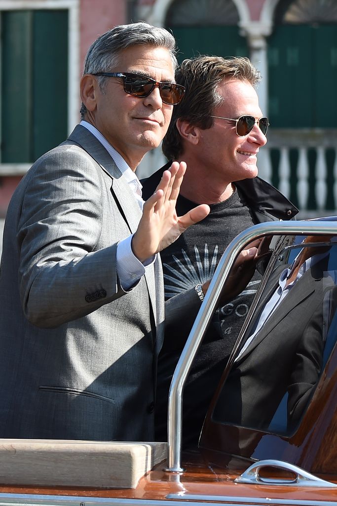 George Clooney waving in a boat with Rande Gerber