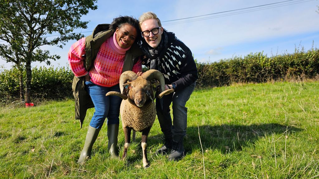 Woman and man posing with goat in field