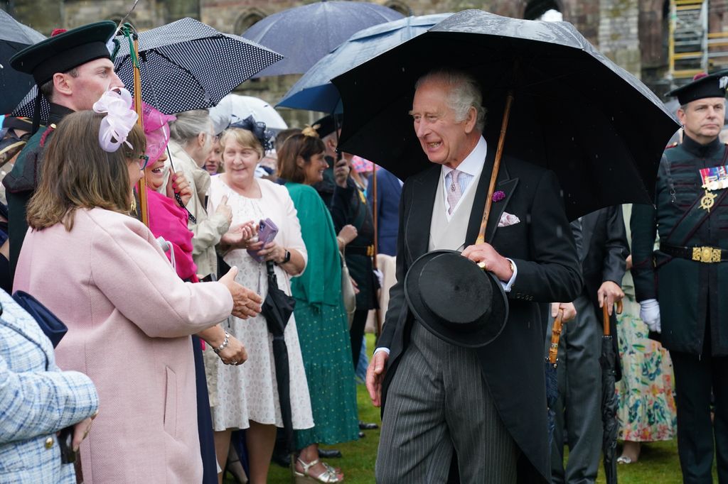 King Charles III greets guests during a Garden Party at the Palace of Holyroodhouse