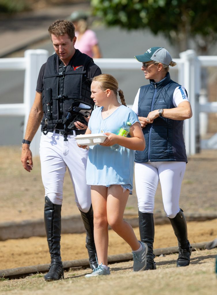 Mia and Zara Tindall walking around in horsey clothes with a horse trainer