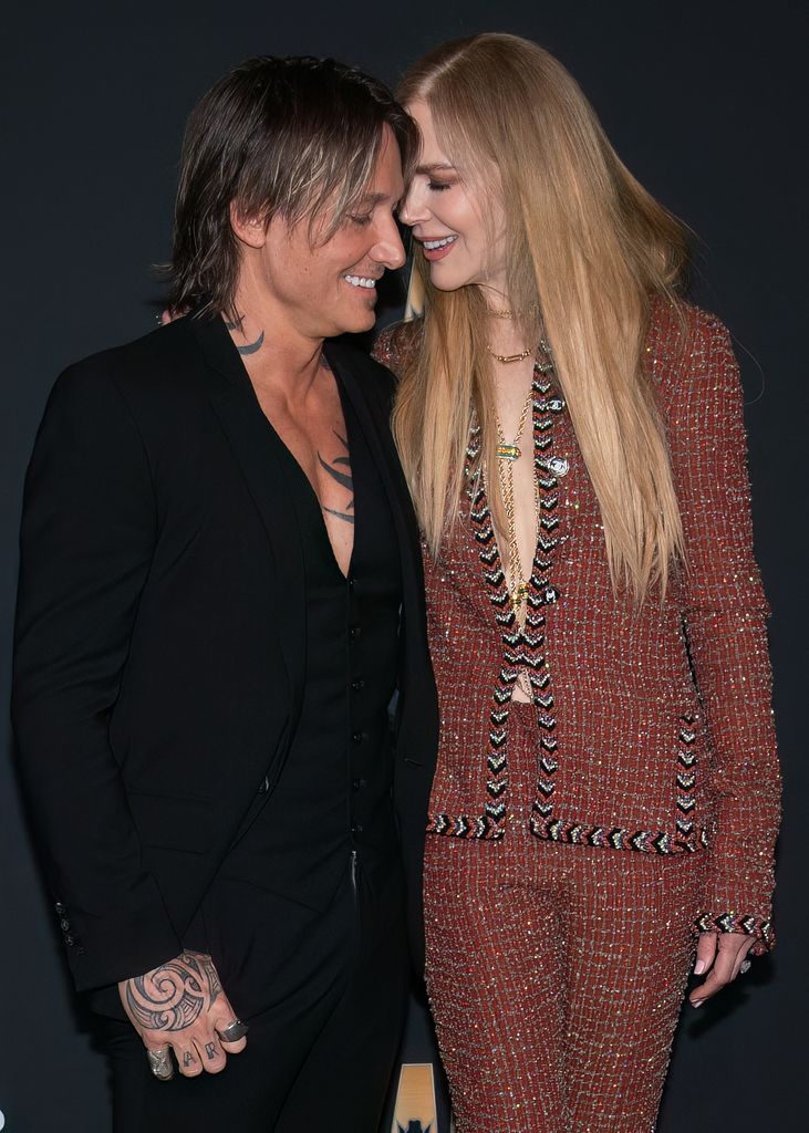 Nicole Kidman and Keith Urban laughing and smiling at each other on a red carpet