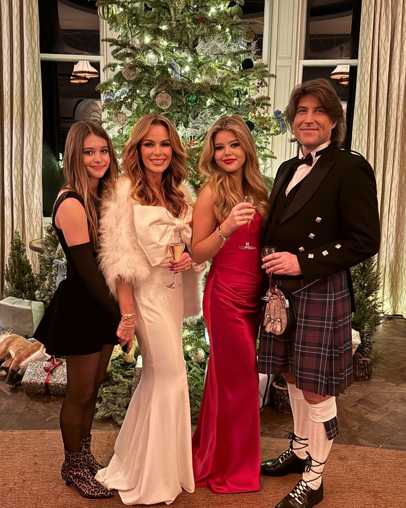 Family posing next to a Christmas tree