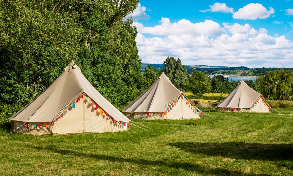 Bell tents with coloured flags in a field