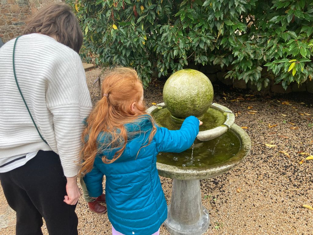 Woman and girl looking at a stone outdoor water feature