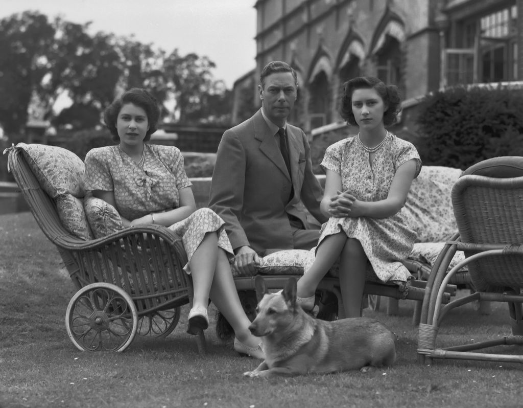A young Queen Elizabeth and Princess Margaret sat with King George VI and a corgi