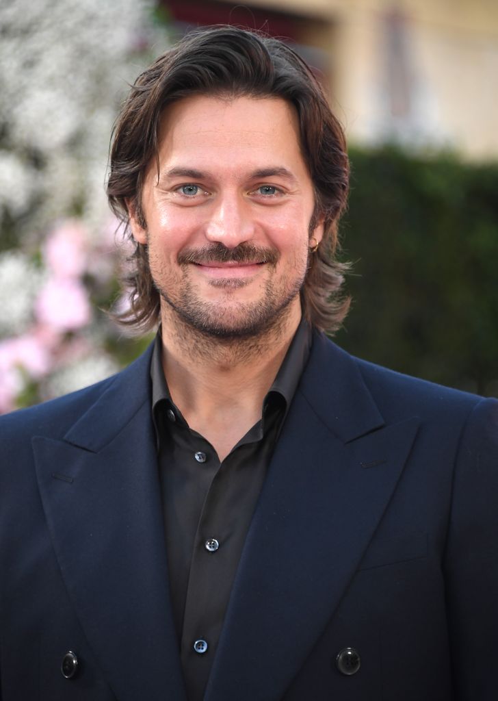 Lucas Bravo in a suit