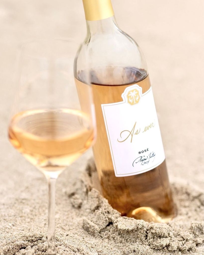 As Ever 2024 Napa Valley rose wine bottle in sand next to glass