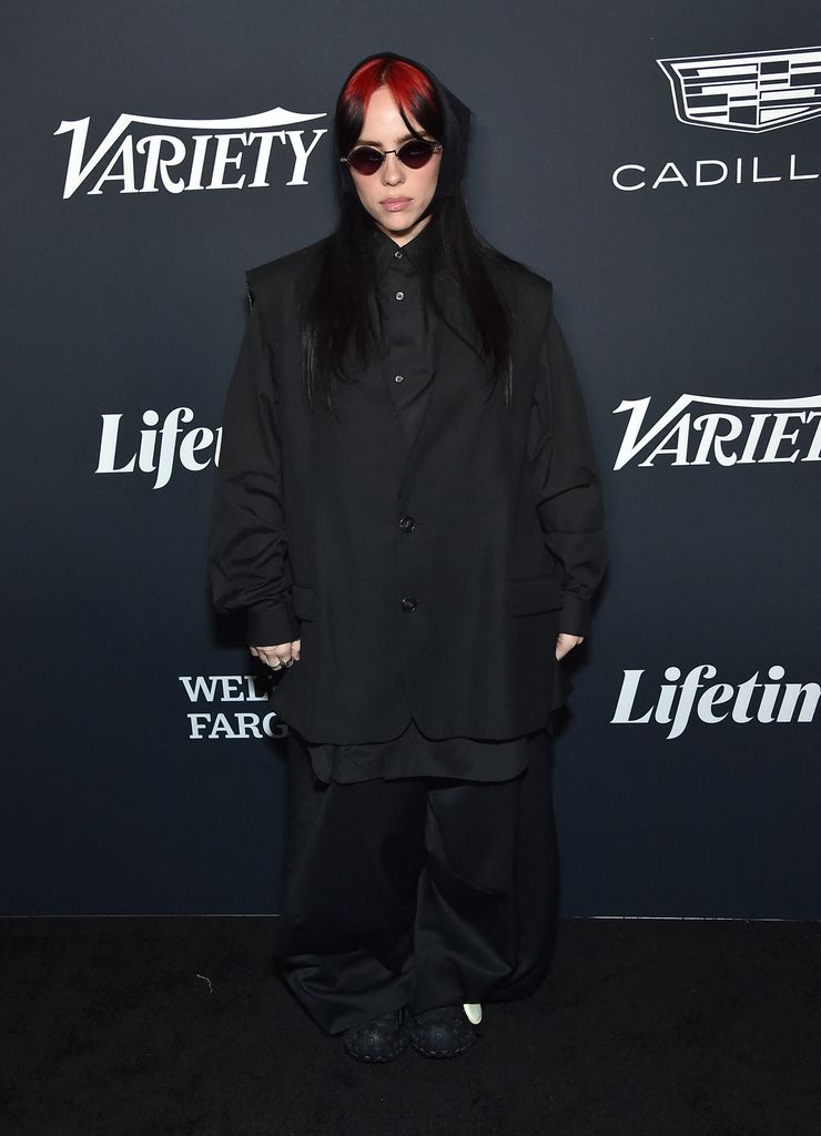 Billie Eilish in black blazer and shirt and red sunglasses