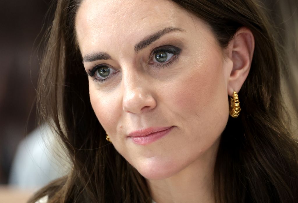 Close-up of Kate Middleton looking serious and wearing gold earrings