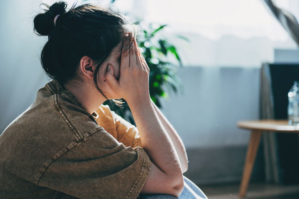 Upset teen girl sit on floor head in hands