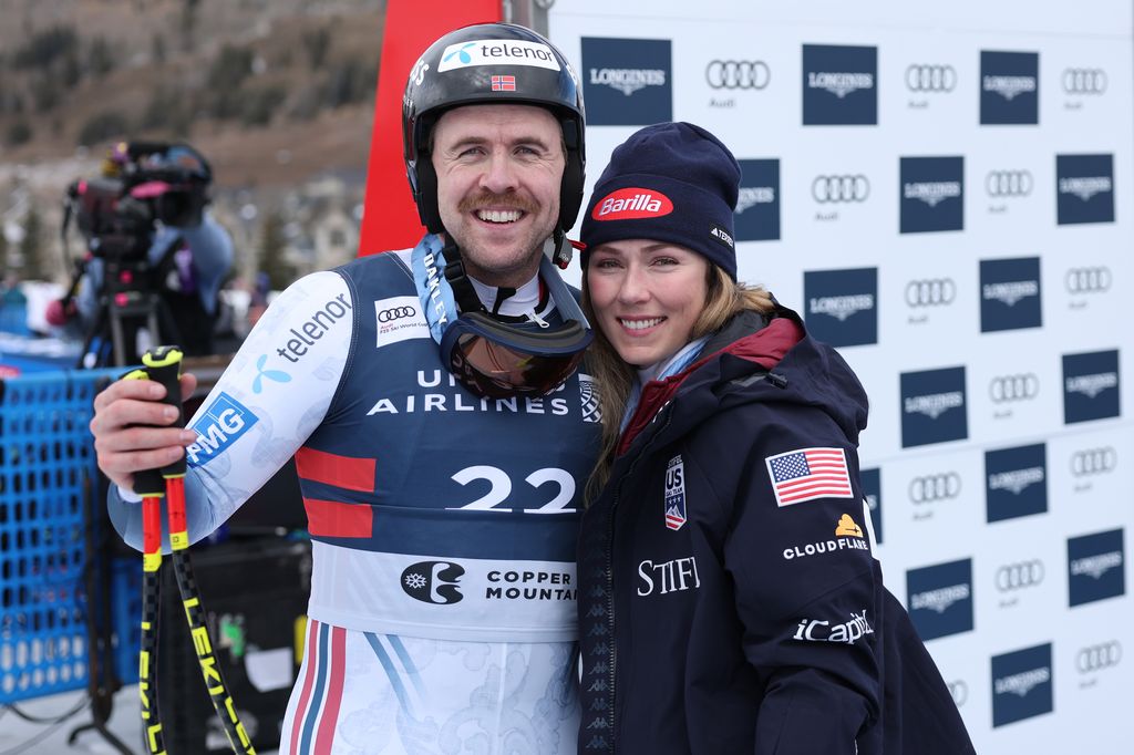Le Norvégien Aleksander Aamodt Kilde (à gauche) pose pour une photo avec sa partenaire, l'Américaine Mikaela Shiffrin, après sa course. Tous deux portent de grands manteaux et des chapeaux.