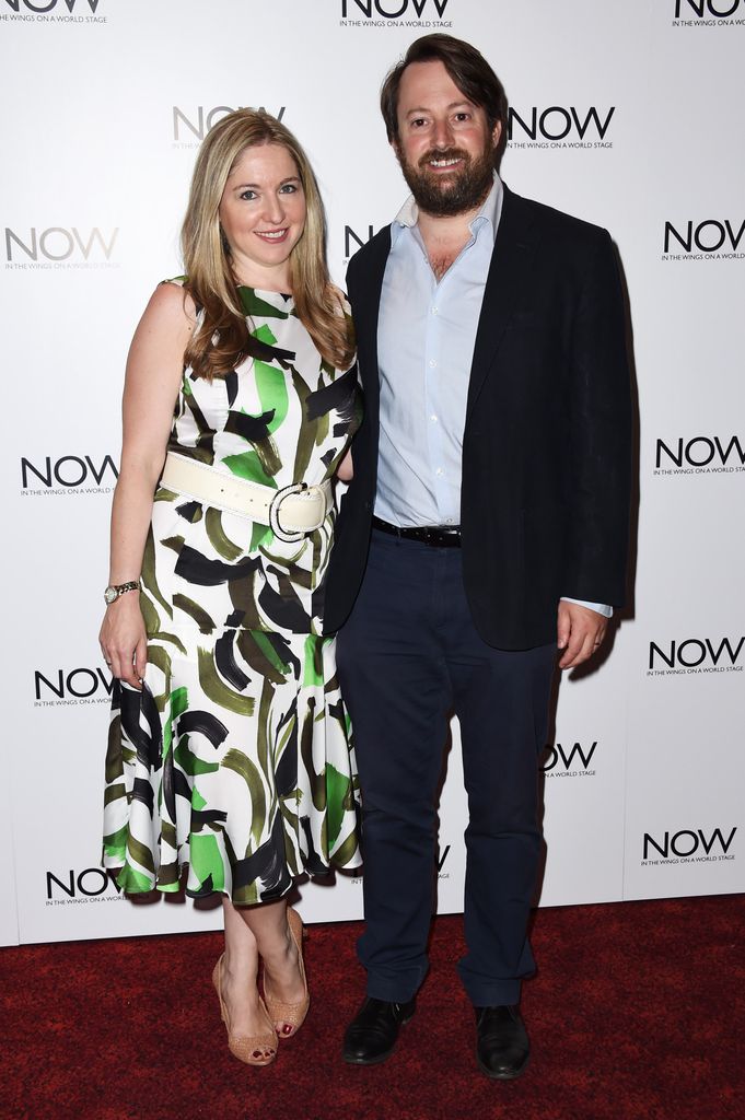 couple smiling on red carpet 