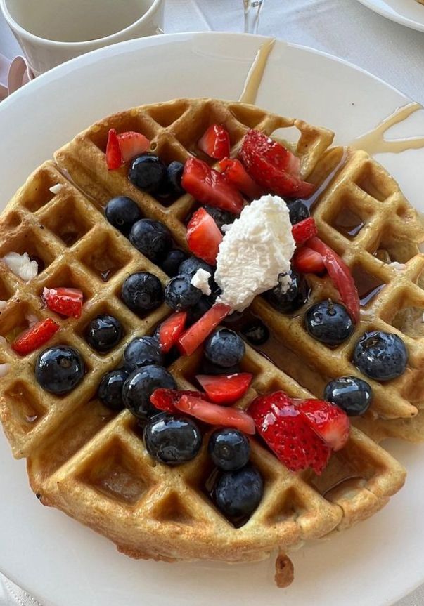 A waffle with blueberries and strawberries