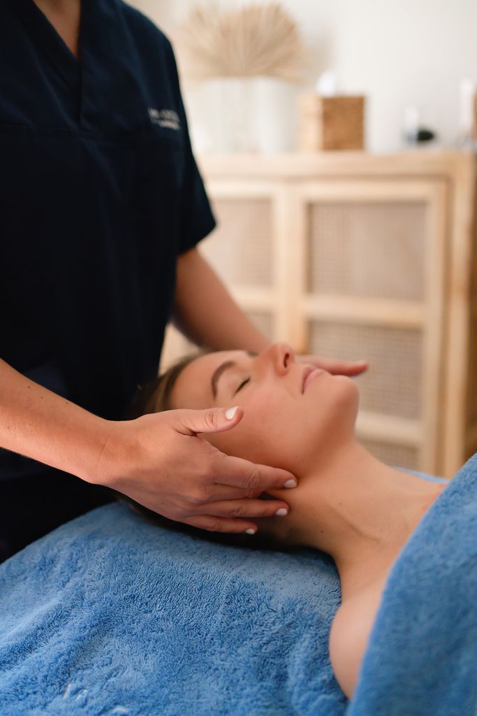 Woman holding her hands against the jaw in a buccal massage