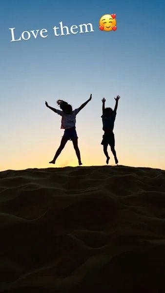 Amelia and Theo Andre jumping on a sand dune in Dubai