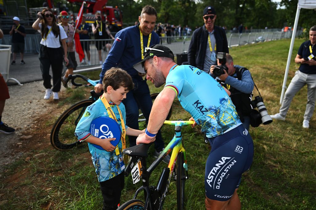 Mark Cavendish and son Frey looking at a bike