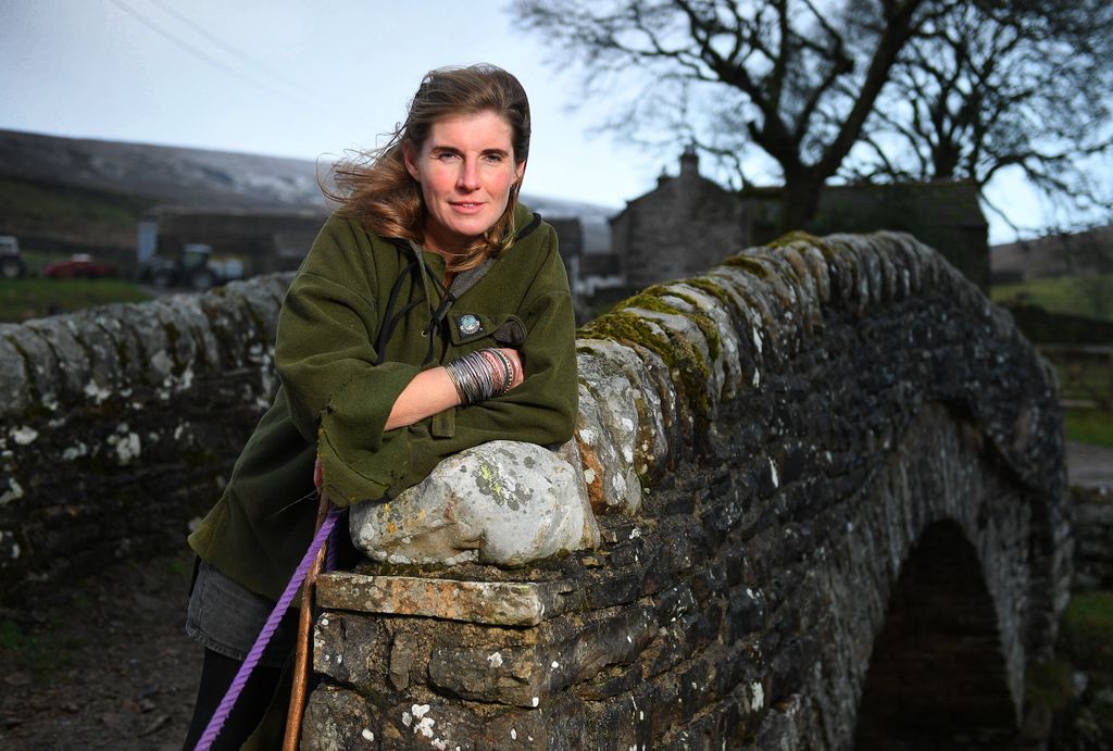 Amanda Owen in a green coat on a bridge