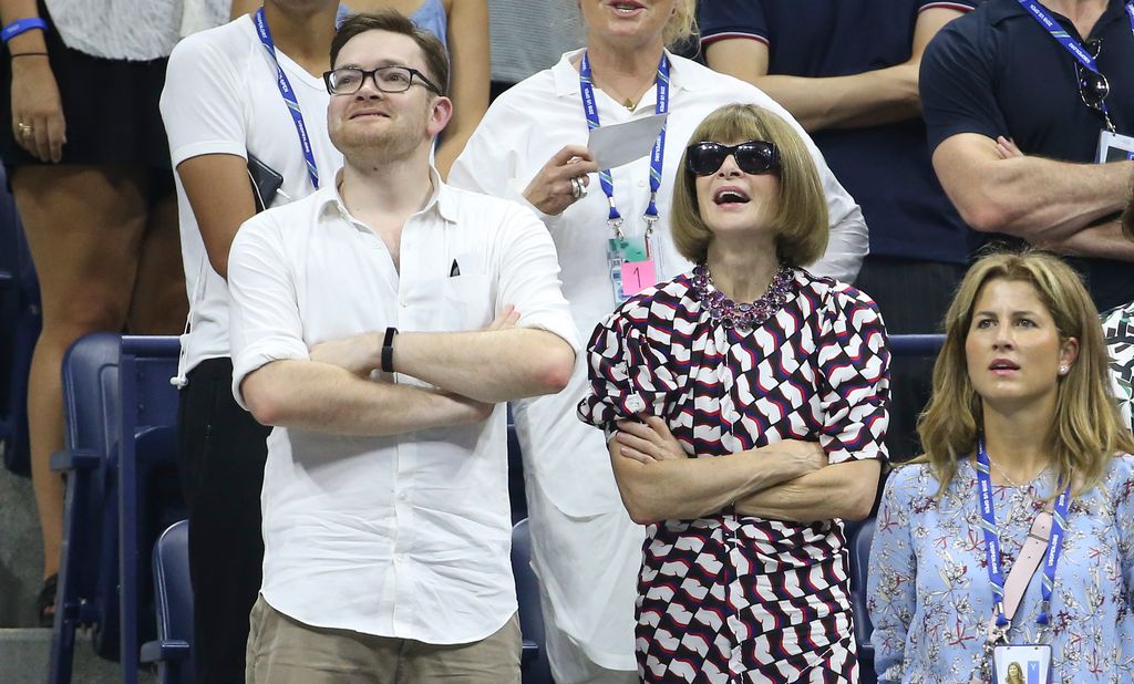 Anna Wintour and her son Charles Shaffer watching the tennis together, both standing with their arms crossed
