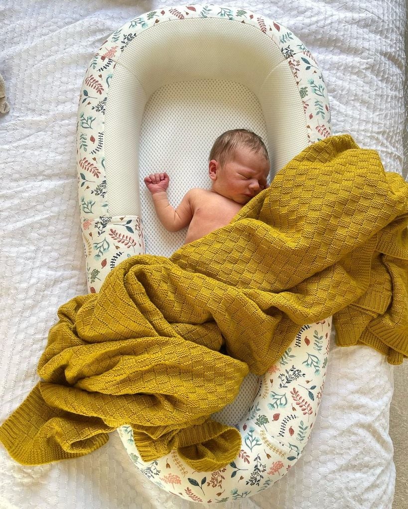 ellie warner photo of baby son sleeping in basket under yellow blanket