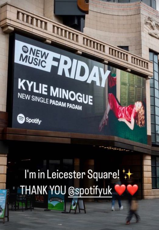 Billboard featuring Kylie Minogue in a red mini dress