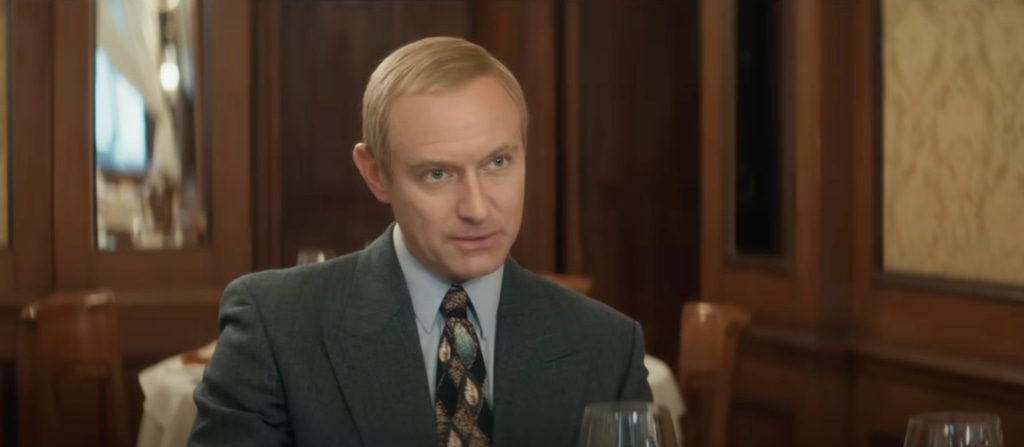 man in suit sitting in restaurant