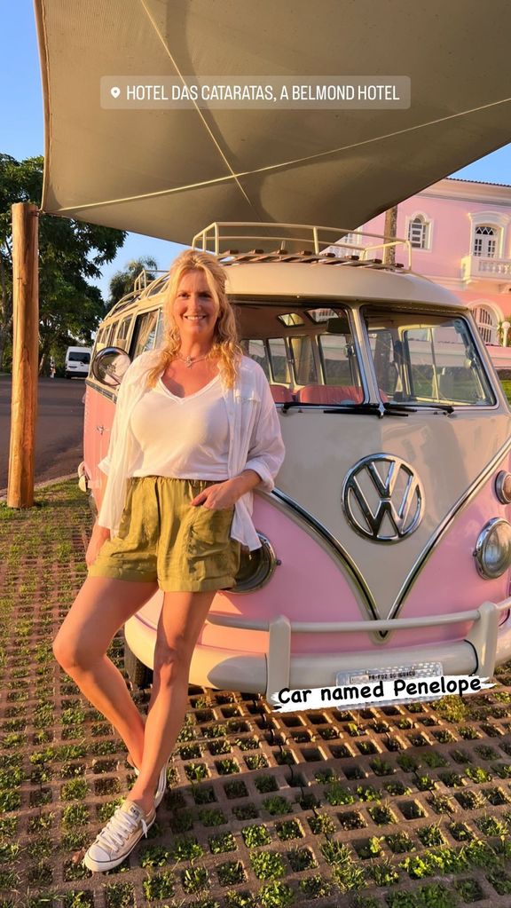penny lancaster posing with pink VW Beetle 