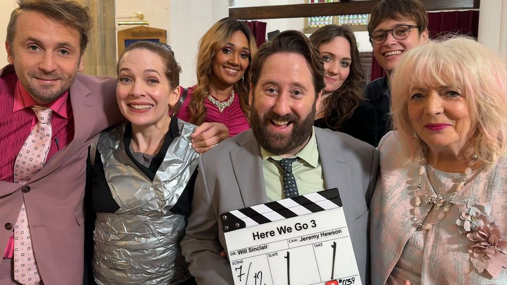 group of actors standing with clapper board