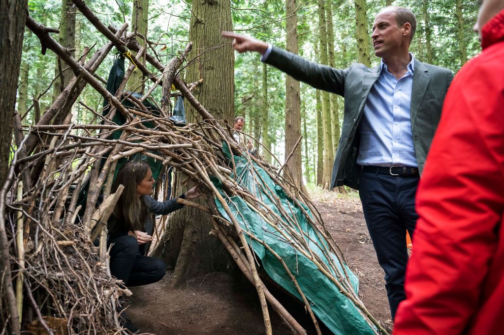 Kate in den made from sticks with william stood beside it
