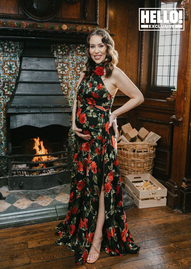 Ellie Phillips showcasing baby bump in black and red floral dress with thigh split 