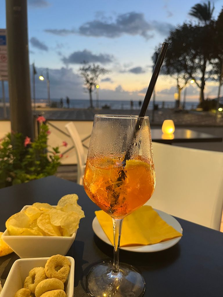 an Aperol spritz and snacks on a table