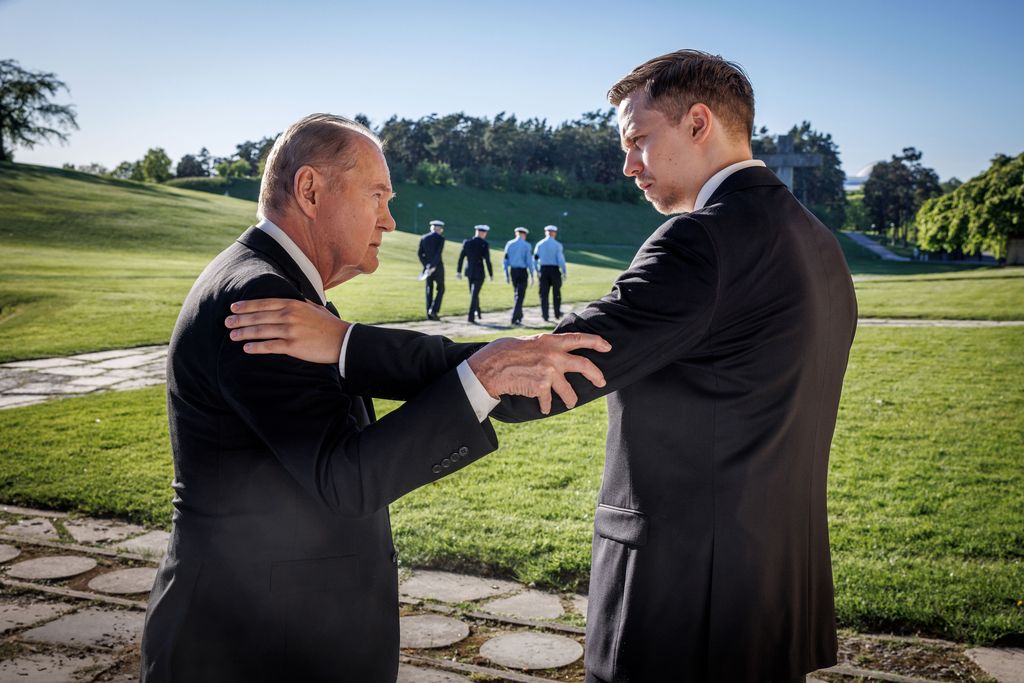 older man and younger man standing outdoors