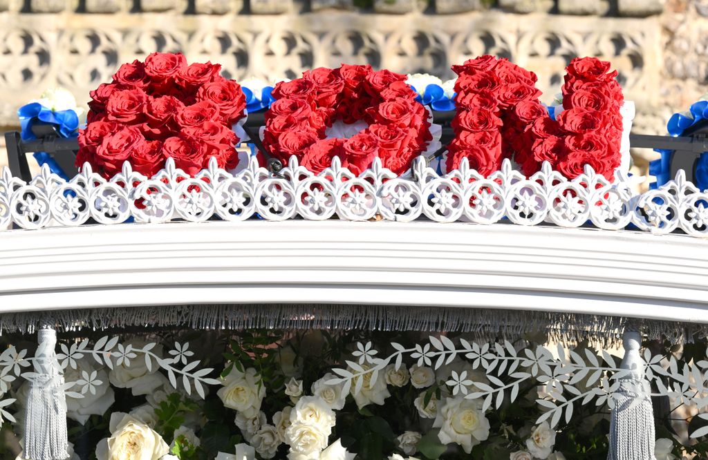 A floral tribute reading 'Son' on top of a hearse