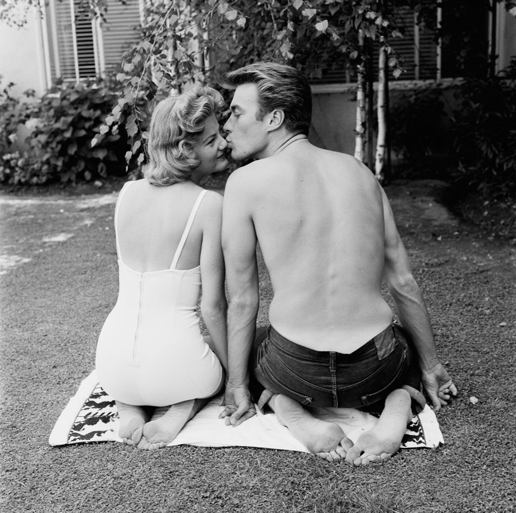 Maggie Johnson, wearing a swimsuit, is kissed on the nose by her husband, American actor and film director Clint Eastwood, in the garden of their home in Los Angeles, California, 9th June 1956