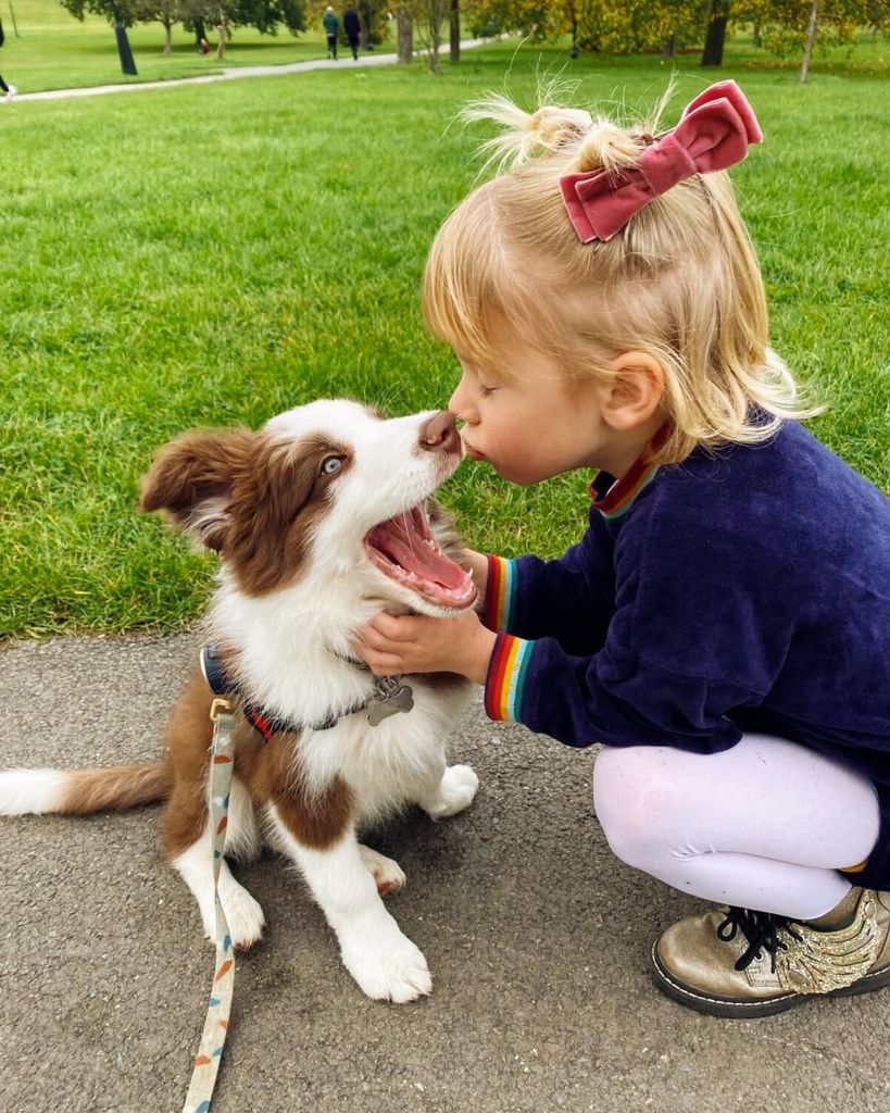 Jamie Oliver's son River wearing a bow in his hair and kissing their pet dog